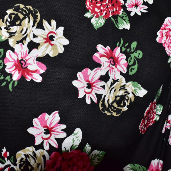 Close up of black fabric with pink and green floral print