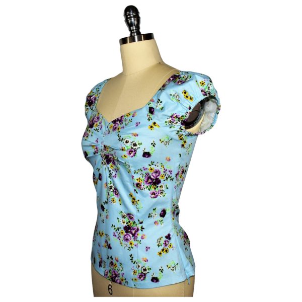 Siren Clothing 50's vintage-inspired top with elasticated short sleeves and front pleat detail in blue floral cotton spandex fabric, side view